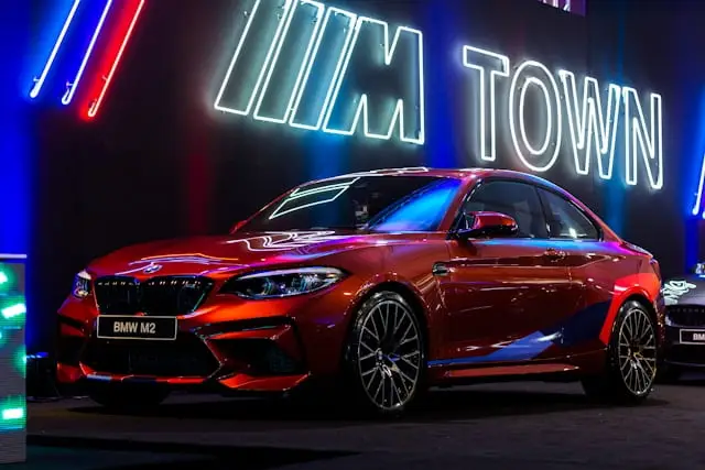 BMW M2 Rouge dans un showroom sombre