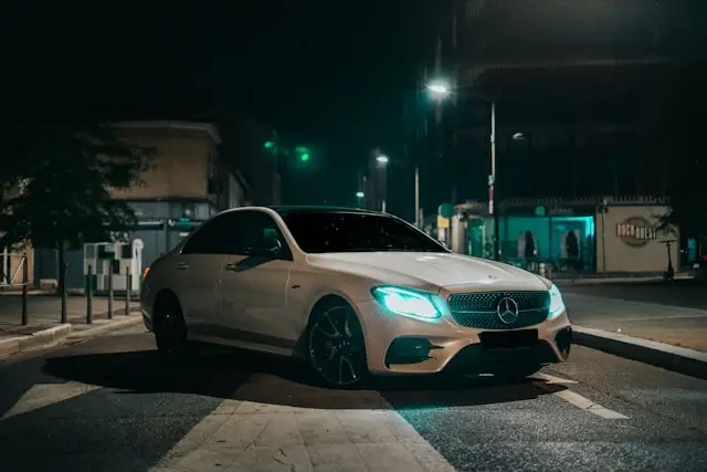 Berline Mercedes blanche moderne de nuit dans la rue