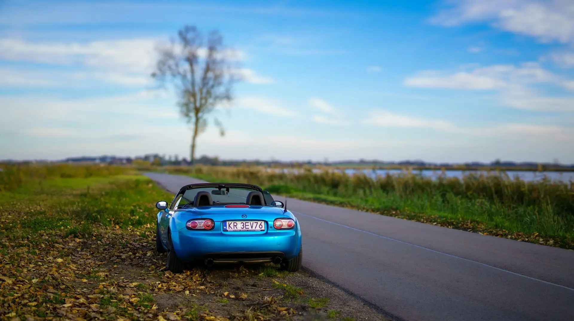 Arrière de Mazda MX-5 décapotée bleue polonaise sur route de campagne