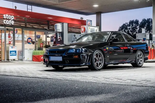 Nissan GTR R34 noire dans une station essence