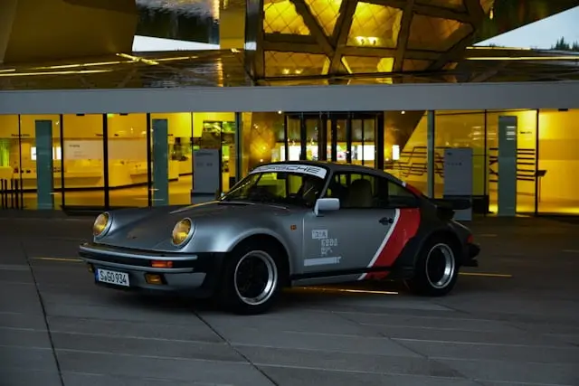 Porsche 930 Grise avec Stickers garée devant concession Porsche