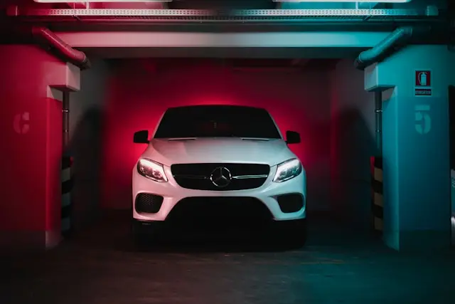 SUV Mercedes Blanc phares allumés garé dans un parking sous-terrain