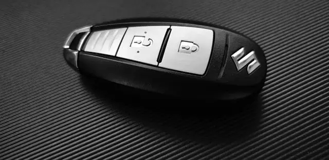 Télécommande clef de voiture Suzuki posée sur fond noir