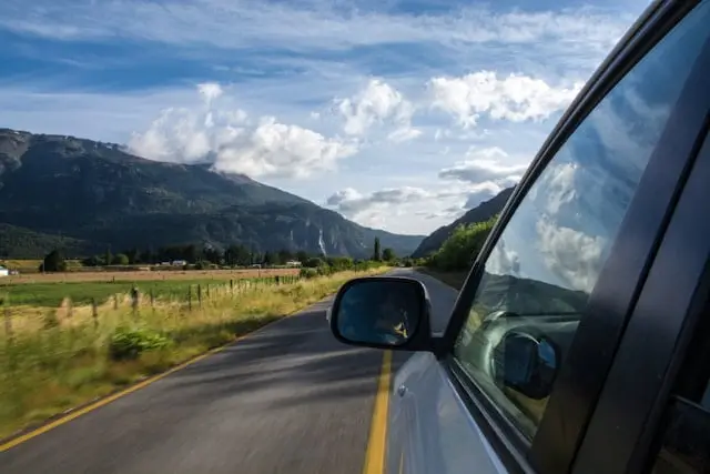 Voiture sur route proche d'une vallée montagneuse en été