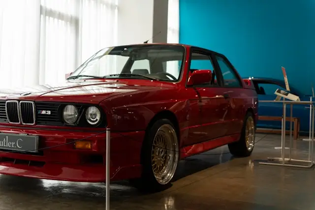 BMW M3 E30 rouge dans un showroom