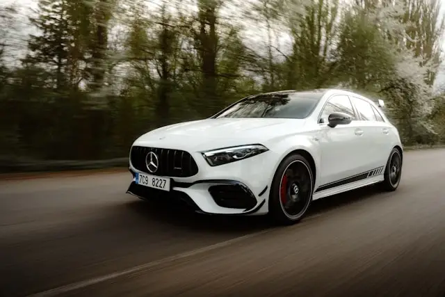 Mercedes classe A45 AMG Berline blanche sur route boisée