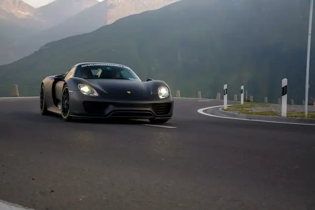 Porsche 918 Spyder noir mat sur route de montagne