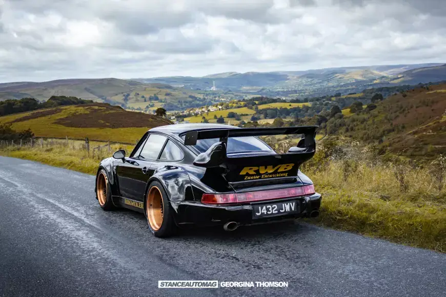 Porsche RWB noire sur rouet de campagne