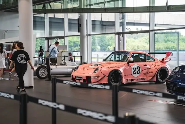 Porsche RWB orange clair exposée dans une concession Porsche