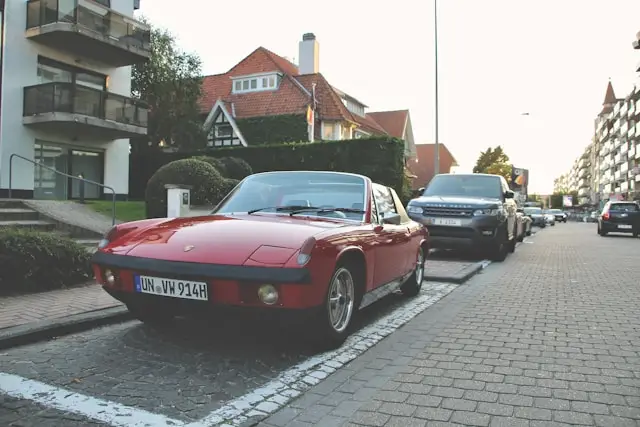 3 quarts avant Porsche 914 rouge garée devant une maison