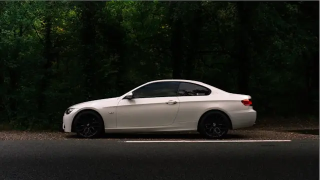 BMW E90 coupé blanche de côté en foret