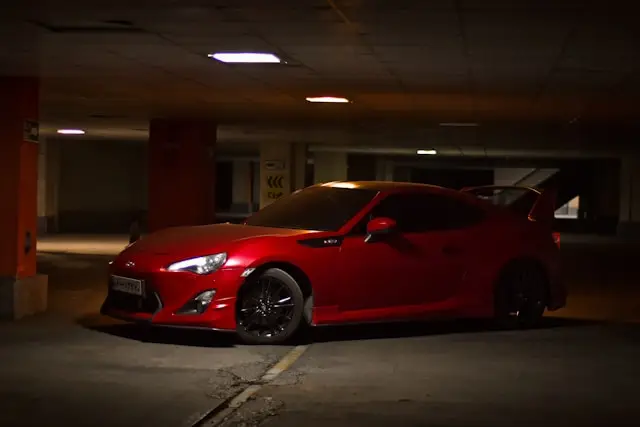 Toyota GT86 rouge mat dans un parking sous terrain