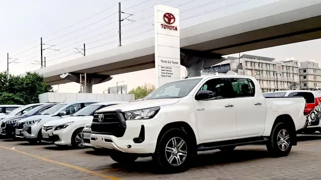 Toyota Hilux blanc neuf sur parking concession Toyota