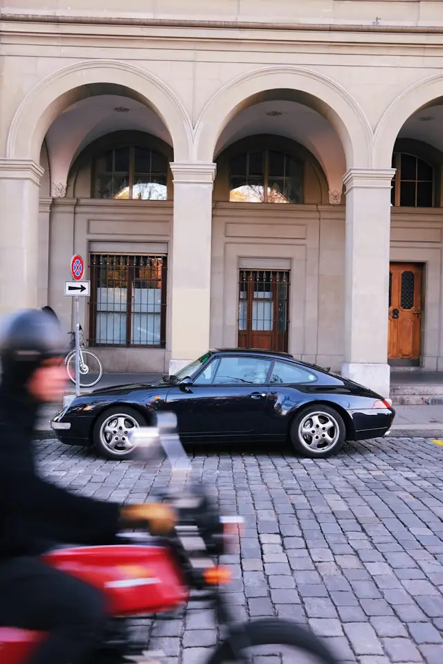 Porsche 993 noire côté garée rue